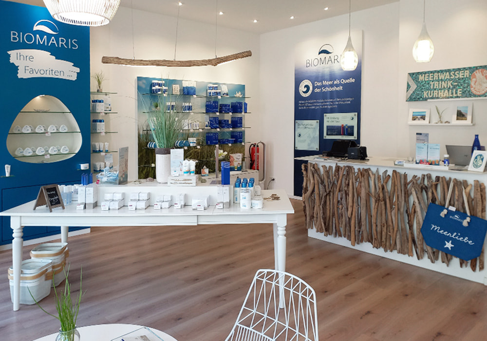 Innenansicht des BIOMARIS-Shops in Heiligenhafen mit Verkaufstheke aus Treibholz, Produktregalen und Werbetafeln 