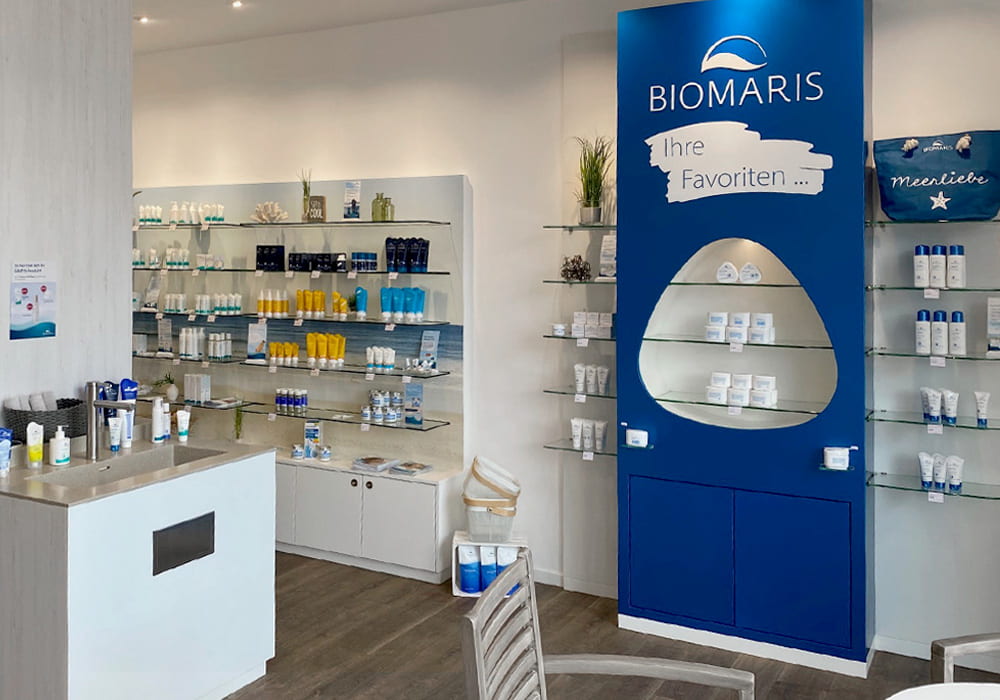 Verkaufsfläche mit Regalen, blauer Produktwand „Ihre Favoriten“